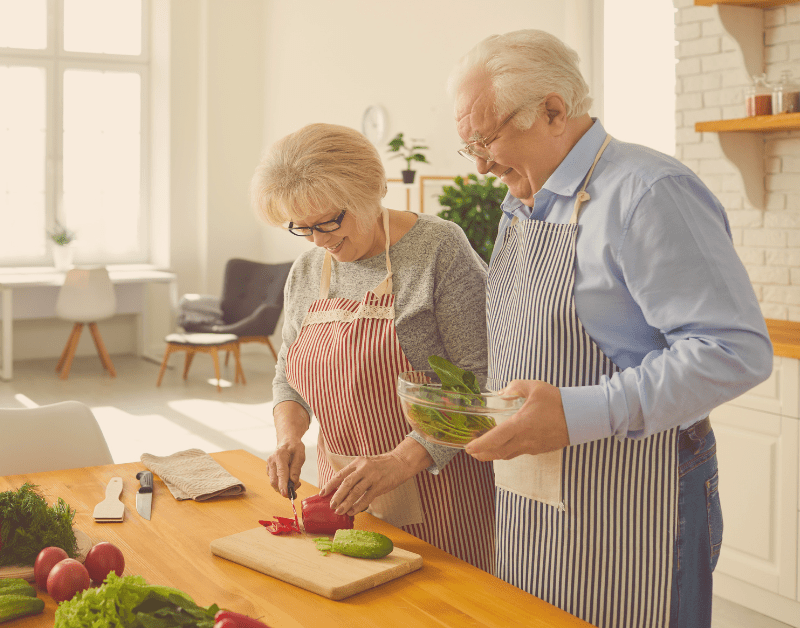 older man and woman making dinner together