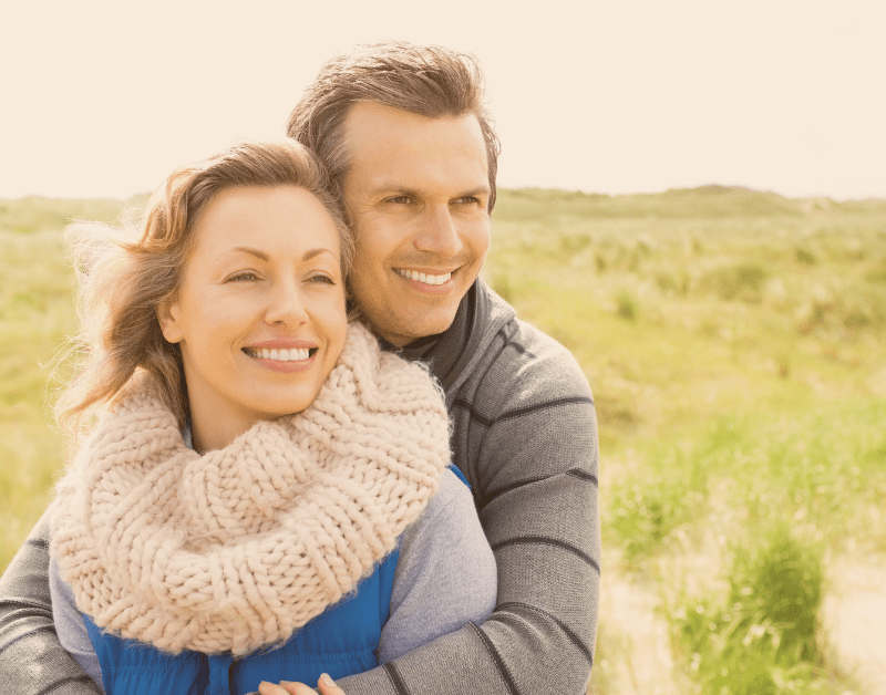 man and woman outside smiling and hugging