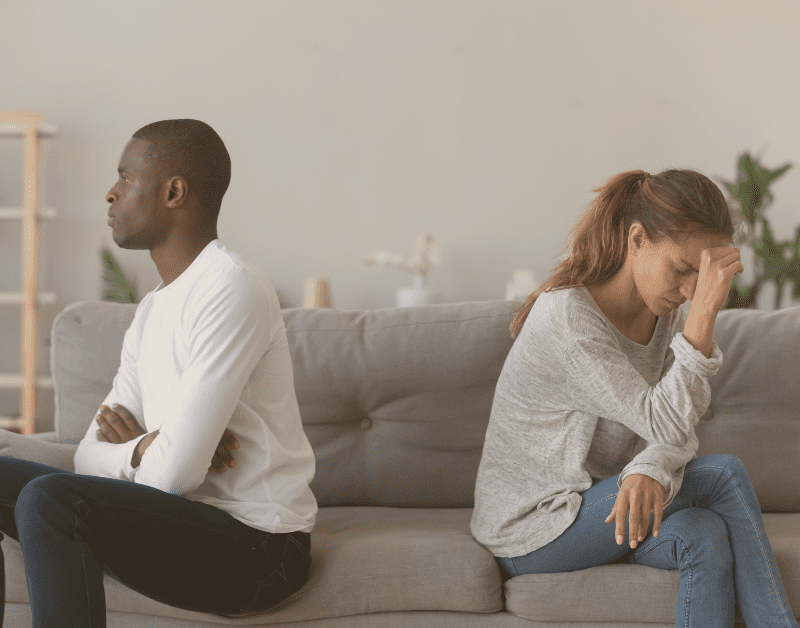 man and woman sitting o n a couch with there backs to each other
