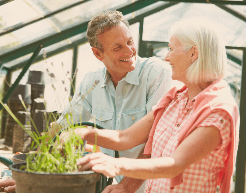 couple smiling at each other and gardening