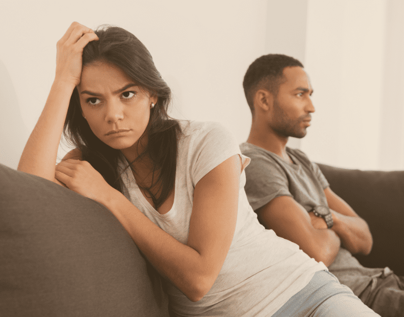 couple sitting on couch not facing each other and not talking