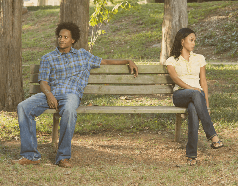 couple sitting separated on a bench